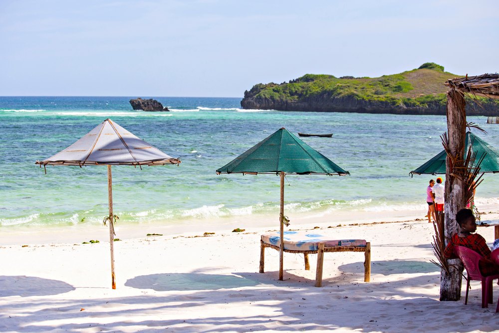 Parasole i stolik na białym piasku plaży Paradise w Watamu