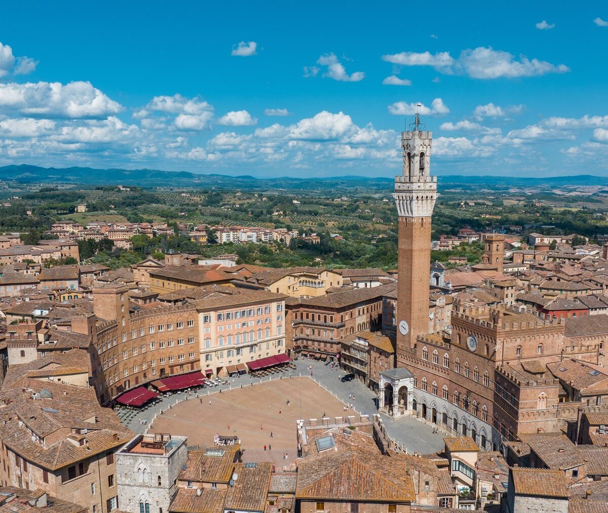 Piazza del Campo w kształcie muszli i Torre del Mangia nad Palazzo Pubblico, wokół ceglane dachy Sieny