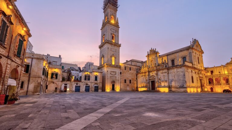Piazza del Duomo w Lecce o świcie, z podświetloną dzwonnicą i barokową fasadą katedry
