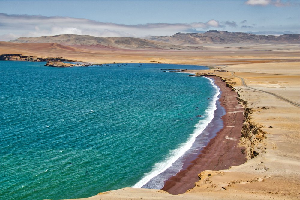 Ocean i czerwona plaża na pustyni w rezerwacie Paracas