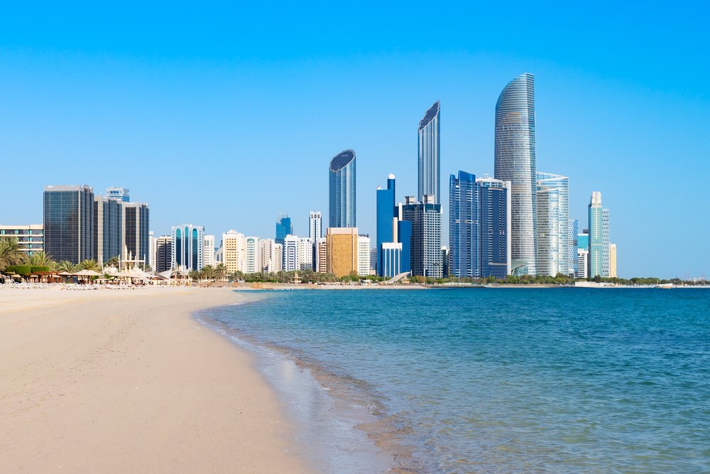 Piaszczysta Corniche Beach z wieżowcami Abu Zabi w tle