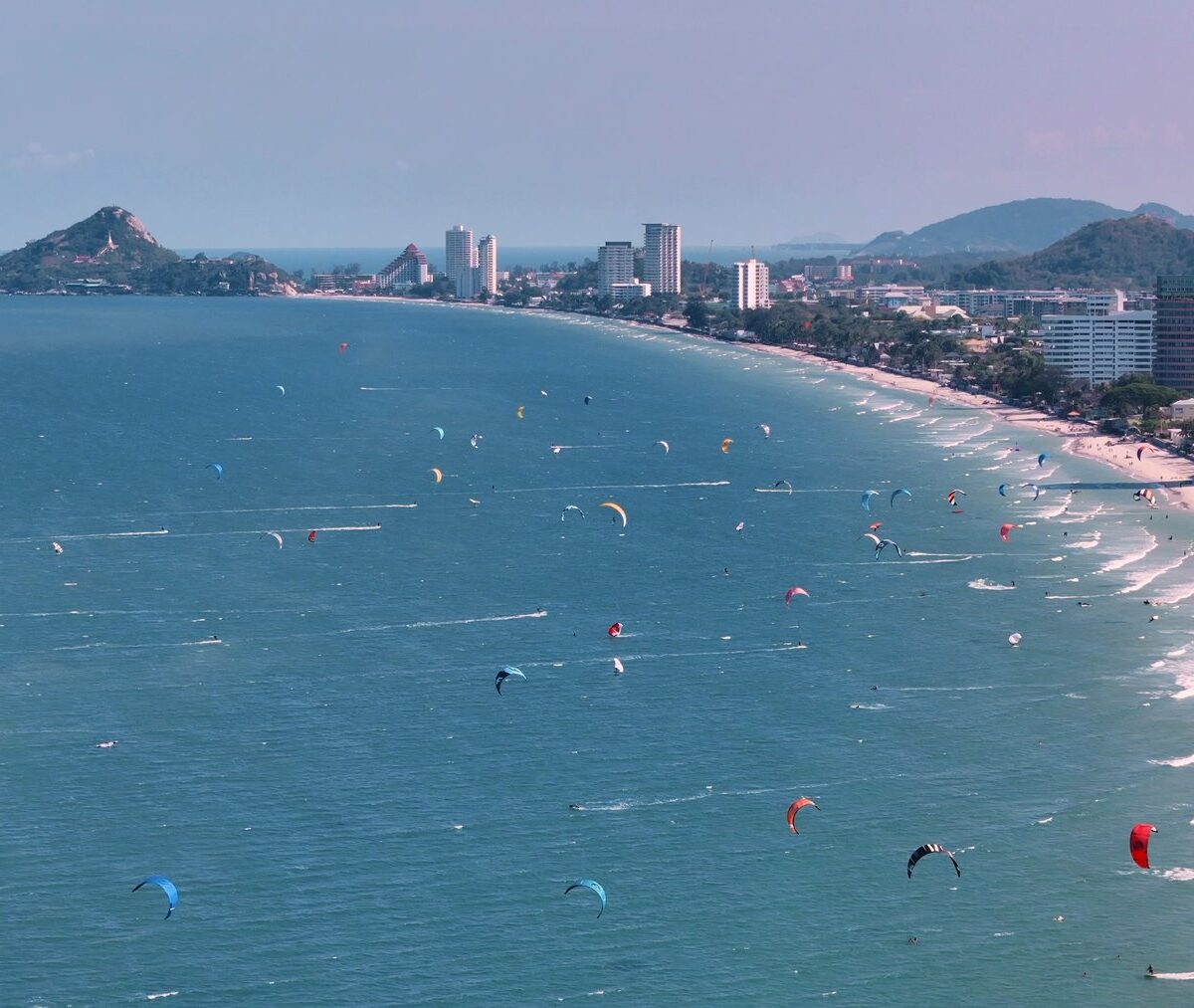 Latawce kitesurferów nad plażą Hua Hin, w tle wzgórze Khao Takiab