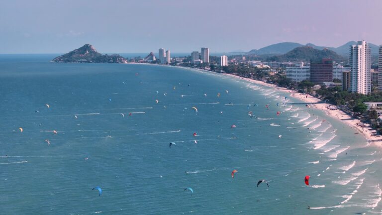 Latawce kitesurferów nad plażą Hua Hin, w tle wzgórze Khao Takiab