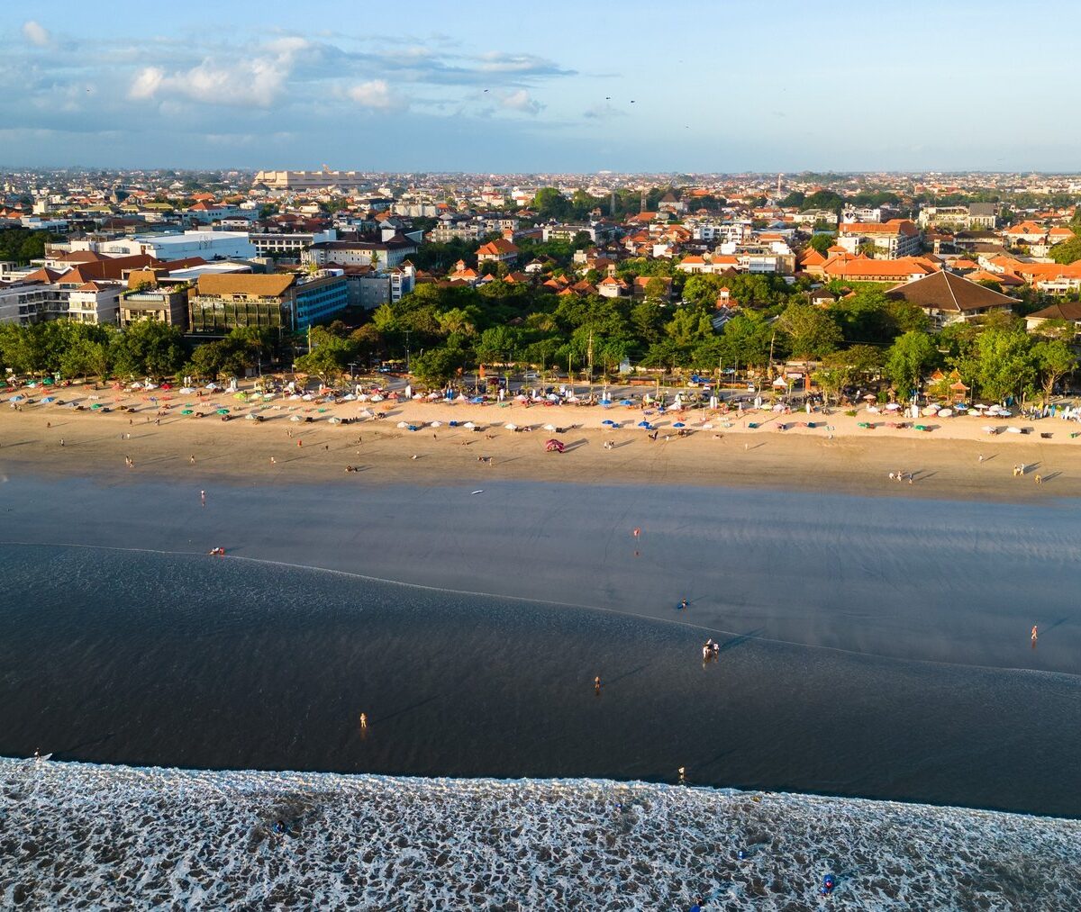Szeroka plaża Kuta na Bali z miastem w tle, z lotu ptaka