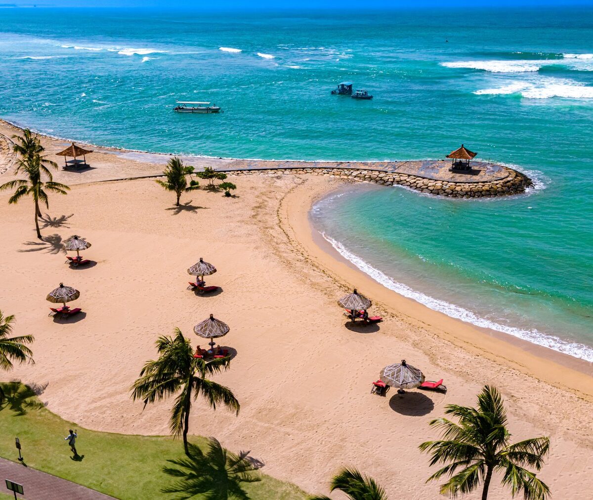 Plaża Nusa Dua z palmami i parasolami w strefie resortów, z lotu ptaka