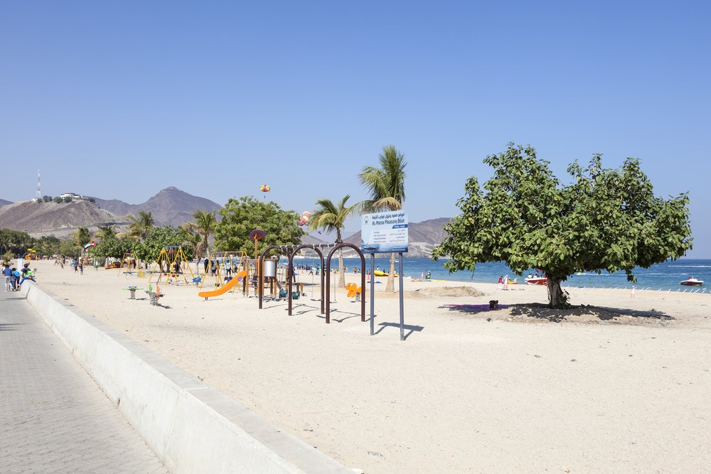 Promenada i plaża w Khor Fakkan z górami Hadżar w tle