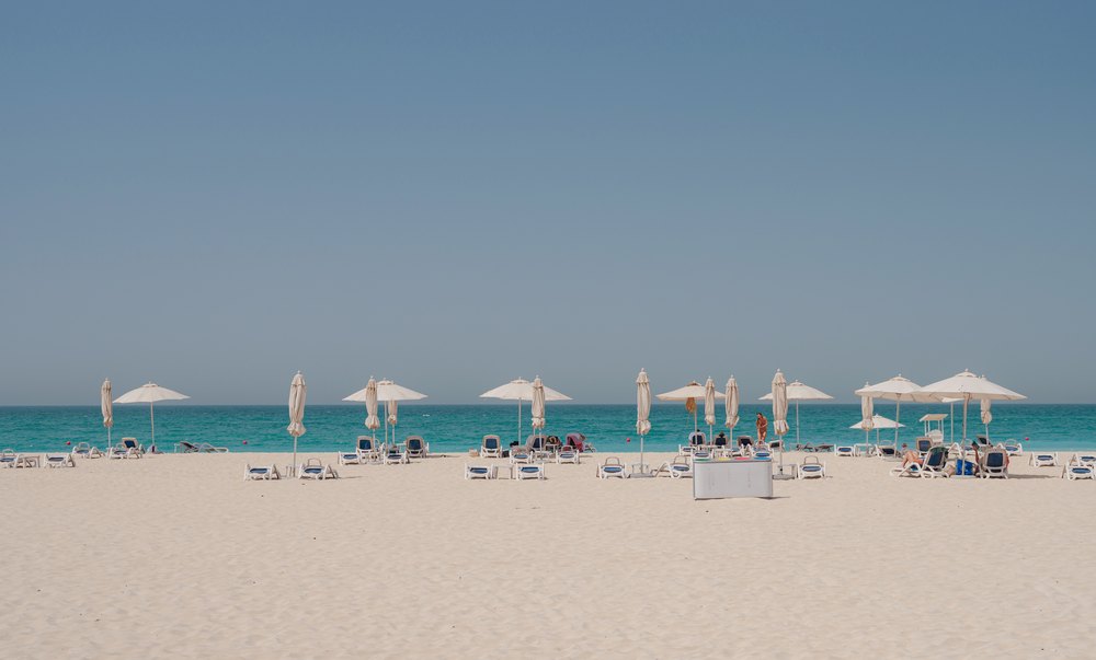 Parasole i leżaki na piaszczystej plaży wyspy Saadiyat w Abu Zabi