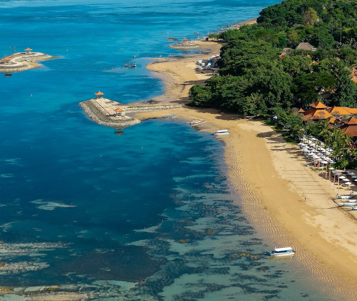 Plaża Sanur ze spokojną wodą i hotelami na brzegu, z lotu ptaka