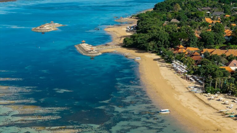 Plaża Sanur ze spokojną wodą i hotelami na brzegu, z lotu ptaka