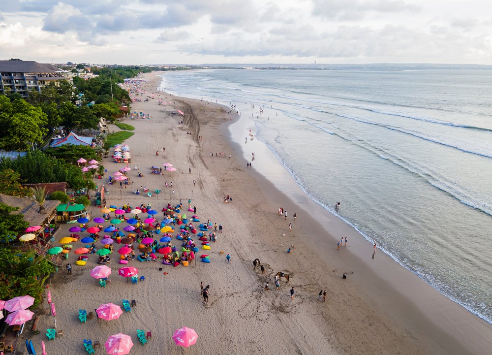 Szeroka plaża w Seminyaku z barem na piasku i resortami w zieleni, z lotu ptaka