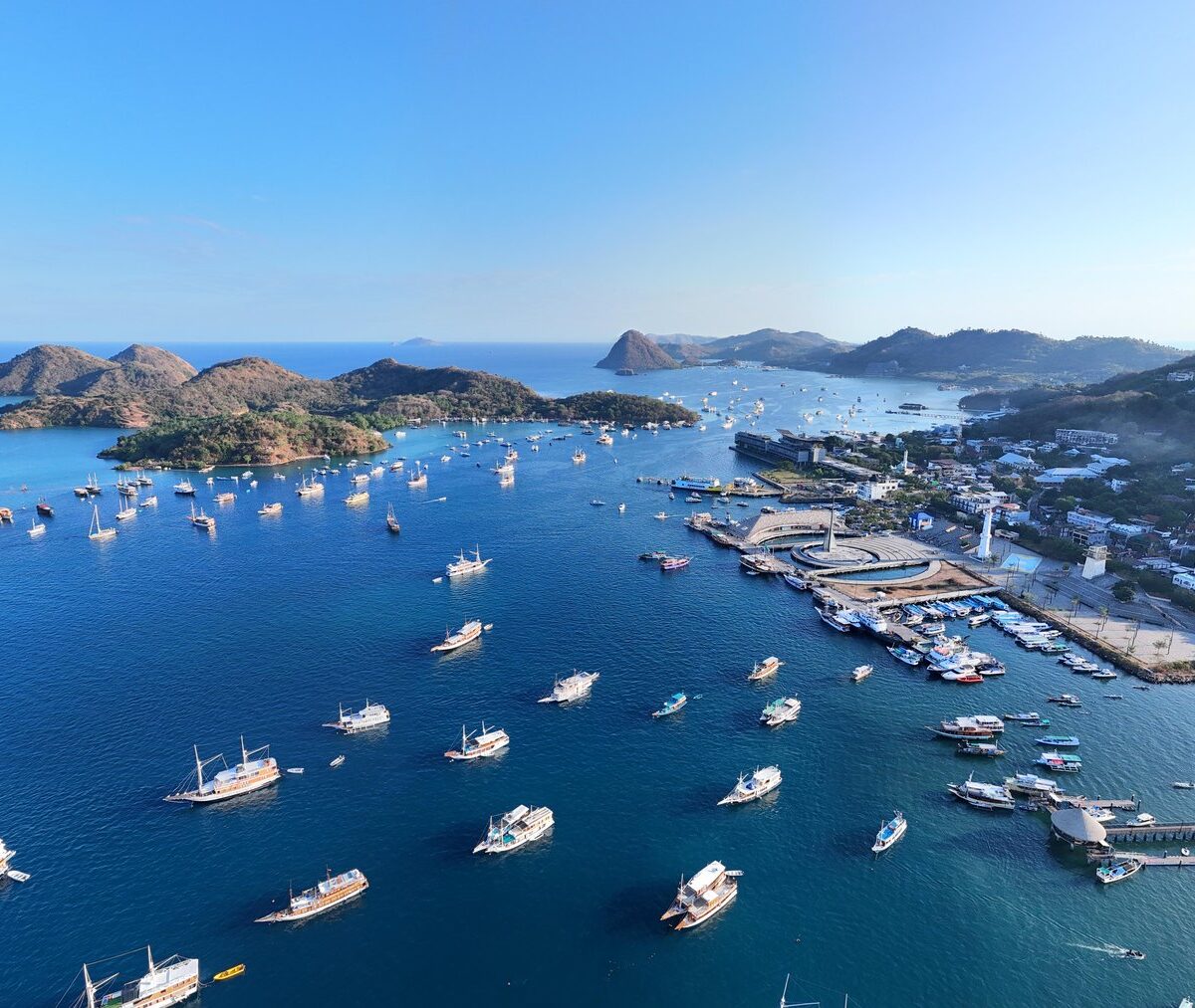 Port w Labuan Bajo z łodziami wycieczkowymi na zatoce, widok z lotu ptaka