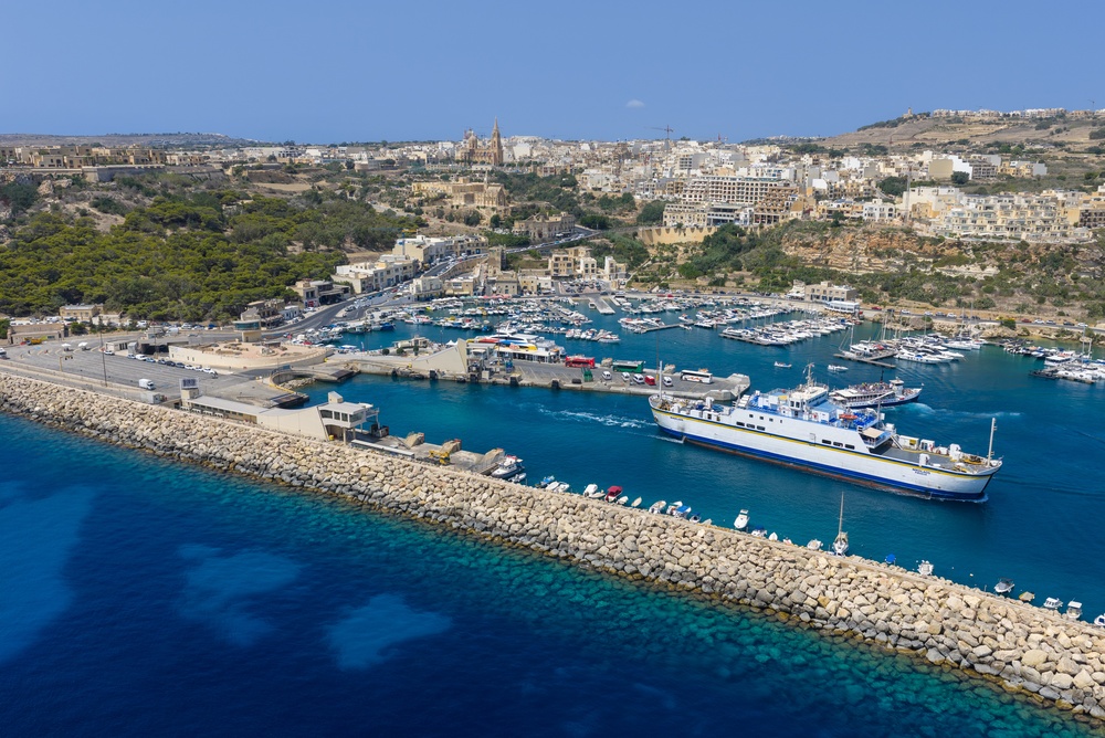Port Mġarr na Gozo z lotu ptaka, prom przy falochronie i marina z jachtami