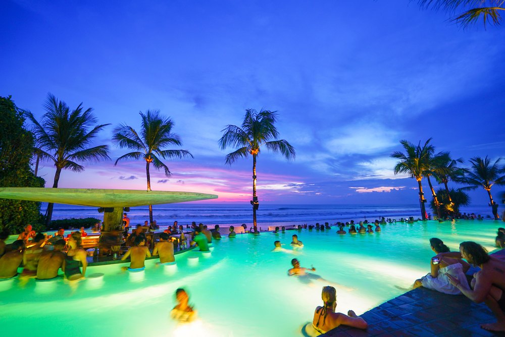 Podświetlony basen Potato Head Beach Club w Petitenget po zachodzie słońca