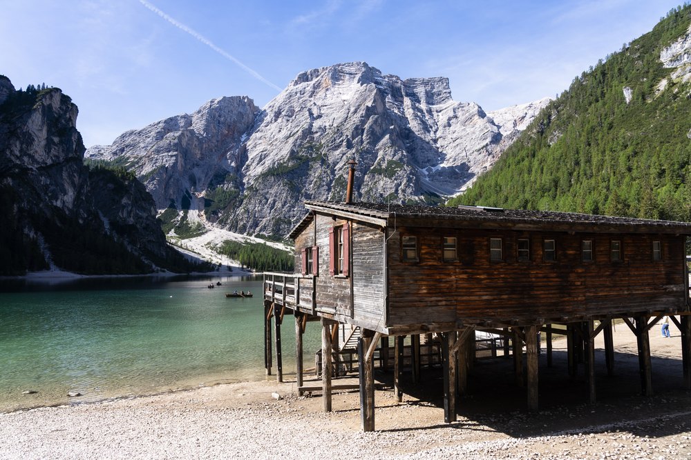 Drewniany hangar na łodzie na palach nad Lago di Braies, za nim Croda del Becco