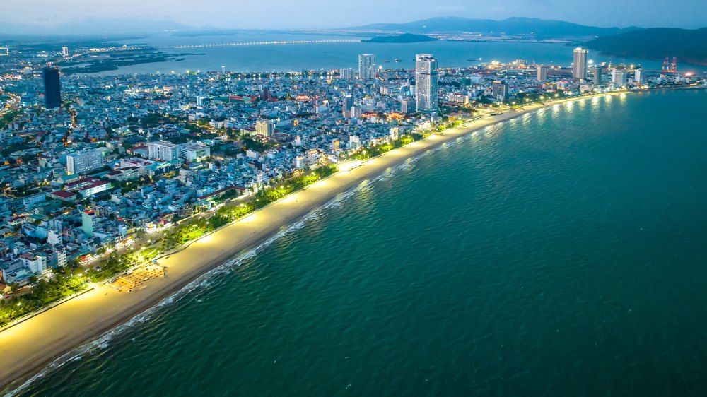 Oświetlona promenada i plaża Quy Nhơn wieczorem z lotu ptaka