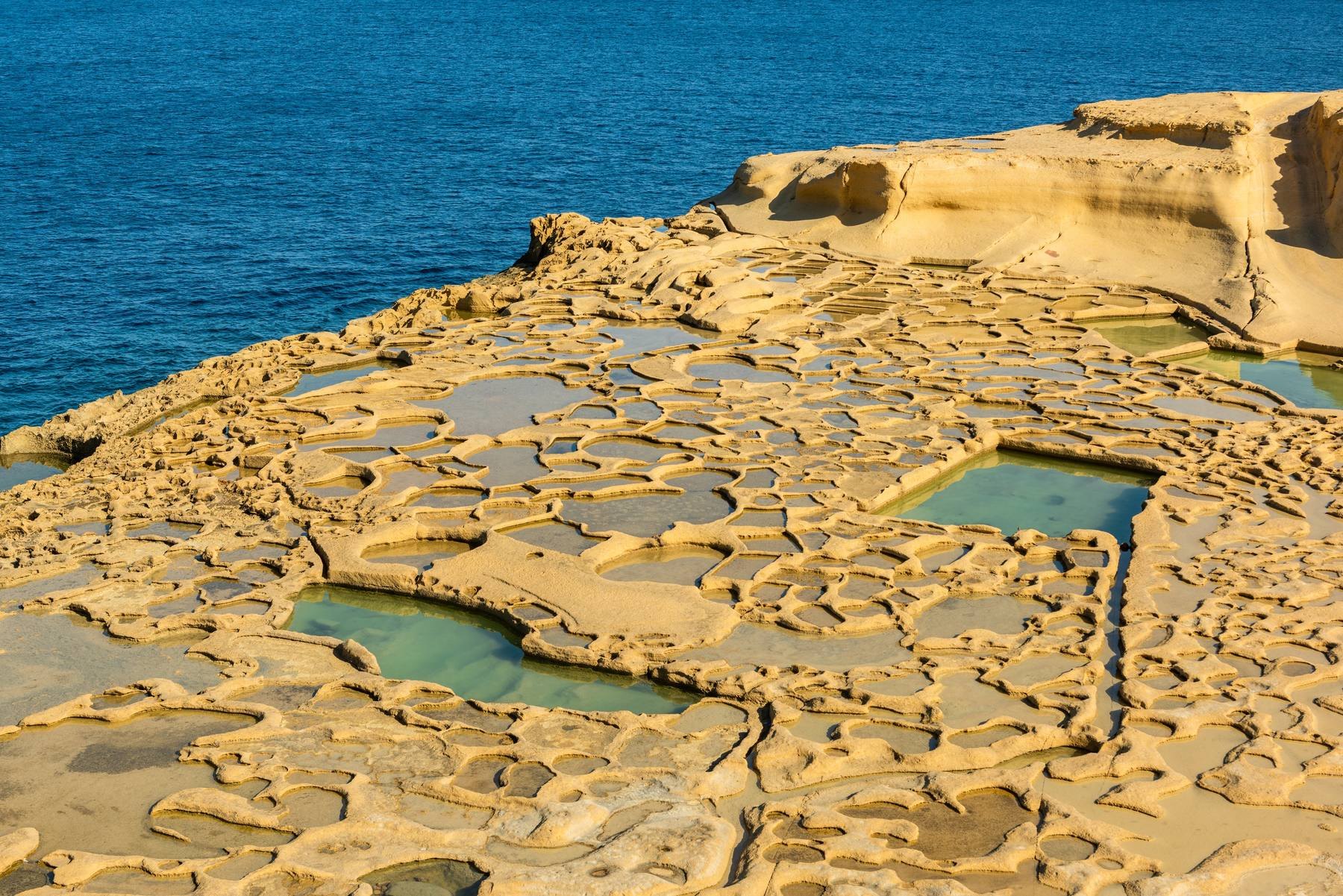 Saliny wykute w skale nad zatoką Xwejni na Gozo, obok morze