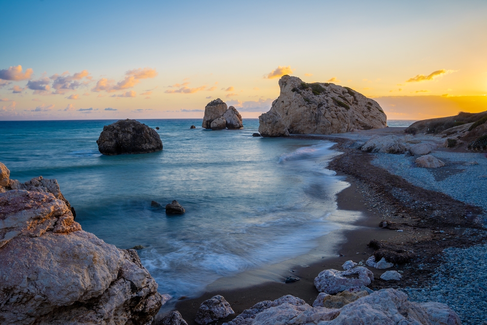 Skała Afrodyty, czyli Petra tou Romiou, o zachodzie słońca, fale na kamienistej plaży