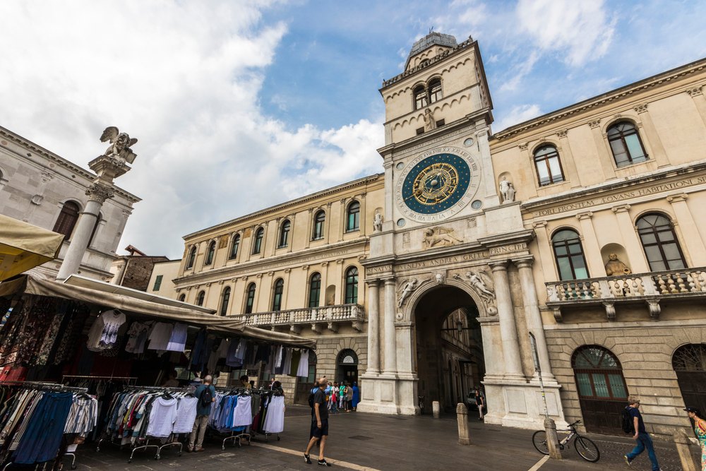 Torre dell'Orologio z tarczą zegara astronomicznego na Piazza dei Signori, przed nią stragany targowe