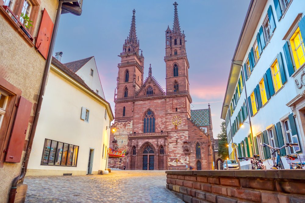 Dwie wieże katedry Münster widziane z brukowanej uliczki Starego Miasta w Bazylei