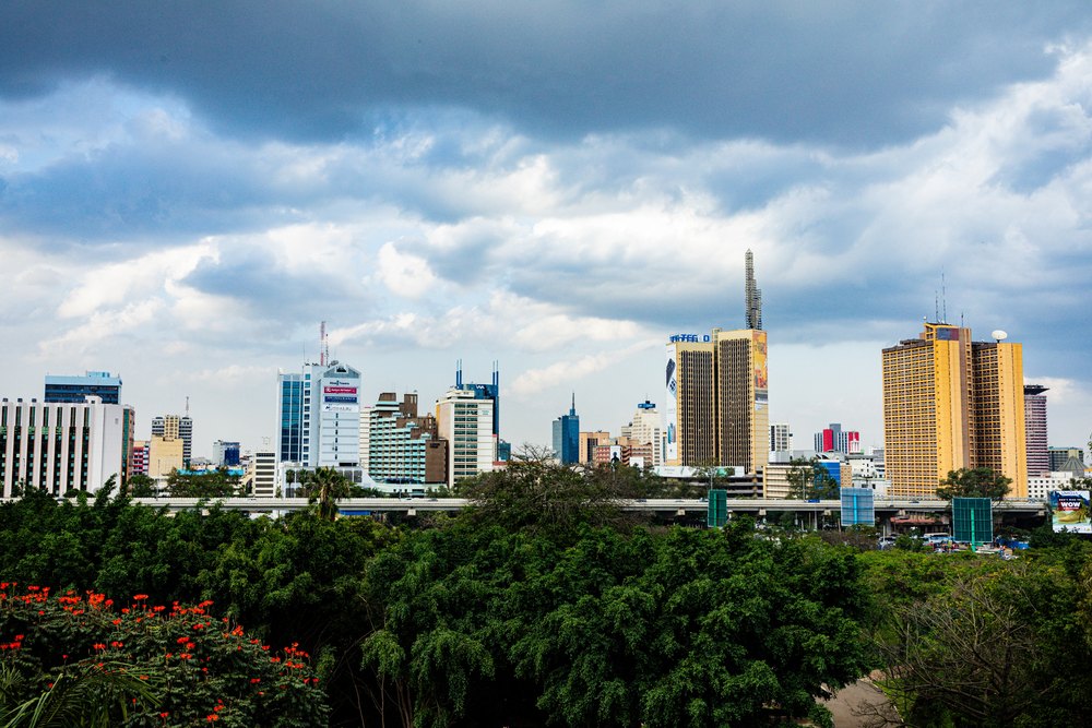 Wieżowce centrum Nairobi nad zielenią pod pochmurnym niebem