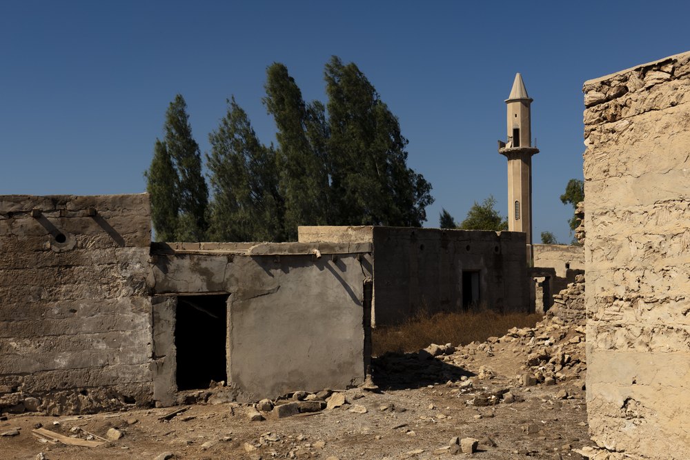 Opuszczone domy i minaret meczetu w dawnej wiosce perłowej Al Jazirah Al Hamra