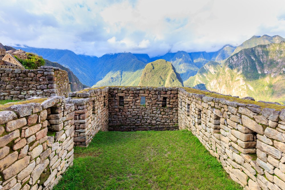 Kamienne ściany i trawa we wnętrzu inkaskiego domu w Machu Picchu