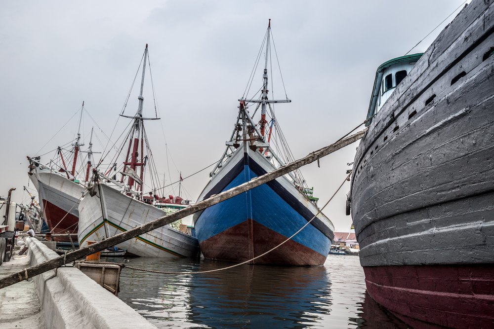 Drewniane żaglowce pinisi przy nabrzeżu starego portu Sunda Kelapa w Dżakarcie